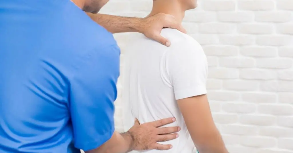 Doctor examining patient's shoulder and side