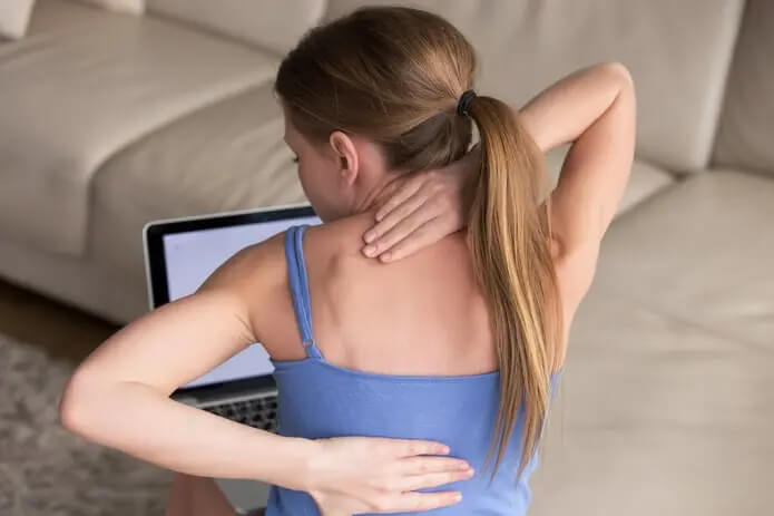 Young female child holding neck and back