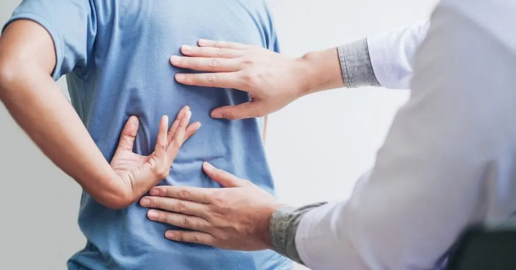 Médico diagnosticando dor nas costas de paciente do sexo feminino