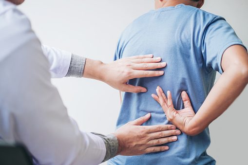 Doctor consulting with patient with back pain