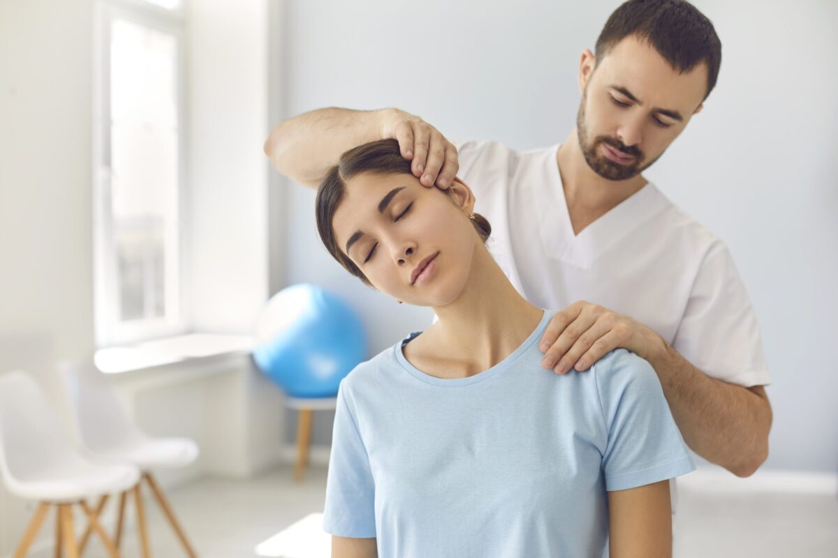 Fisioterapeuta ajudando uma paciente a alongar o pescoço