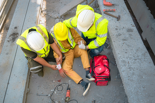 Un trabajador de la construcción herido mientras otros dos le ayudan a levantarse