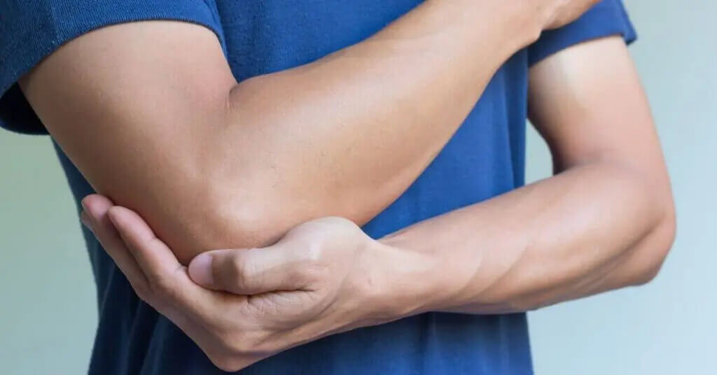 Man holding elbow in pain