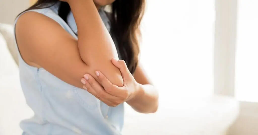 Woman holding elbow while in pain