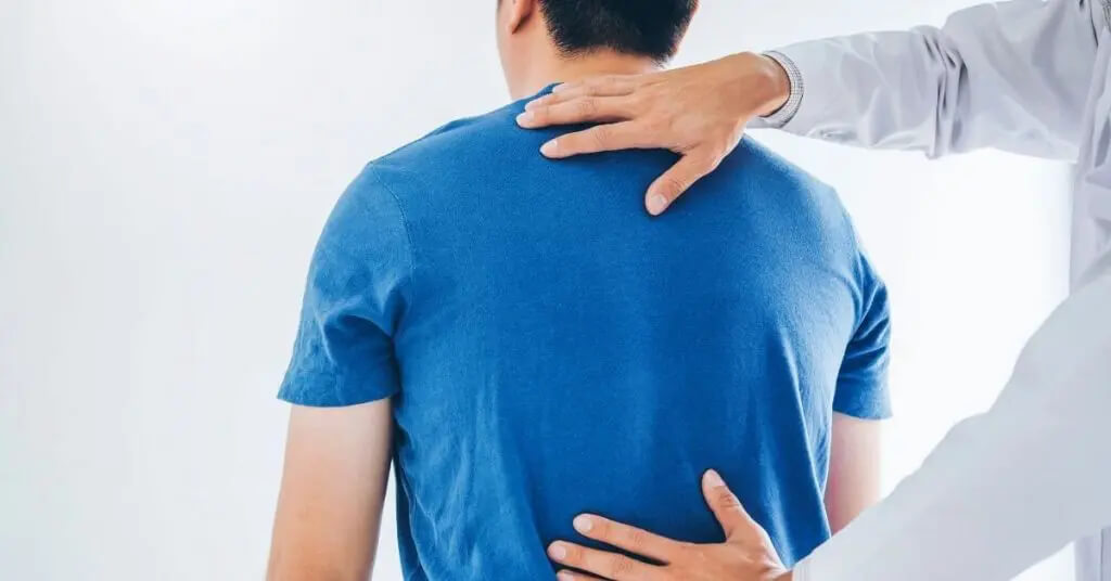 Médico examinando la espalda de un joven